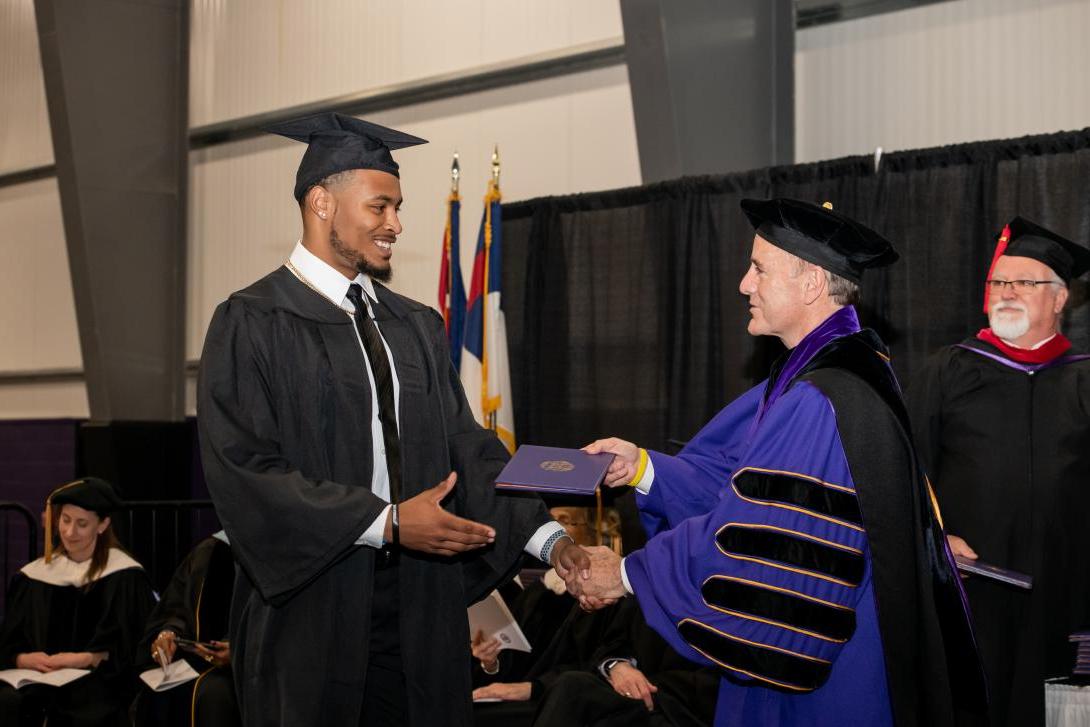 graduate receiving his diploma